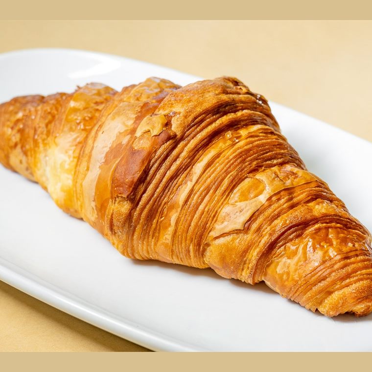 A plain butter croissant on a white plate.