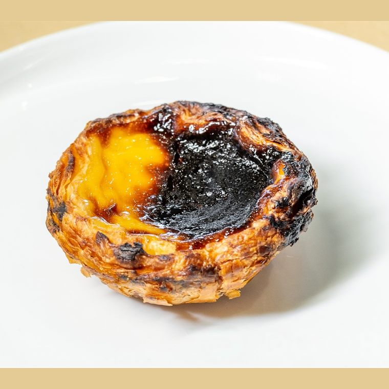 A Portuguese custard tart with a flaky pastry case and a caramelised top.